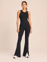 Conjunto deportivo compuesto por un top básico sin mangas de cuello redondo y una calza acampanada de tiro alto con aberturas laterales en el ruedo. Ambas piezas son de color negro y presentan un diseño minimalista.