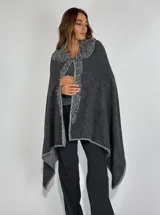 Ruana gris oscuro de lambswool con cuello y bordes bordados a mano en gris claro.