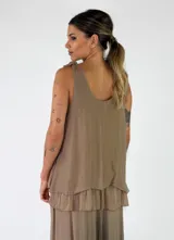 Top de viscosa color marrón tostado, sin mangas, con escote redondo y detalle de lazos para anudar en los hombros. Presenta un diseño de capas con volados en el ruedo.