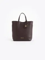 Cartera tipo tote bag pequeña de cuero vacuno negro con diseño de abejas grabadas en bajo relieve. Cuenta con doble asa de mano, correa ajustable y un tag colgante con dije metálico en forma de abeja.