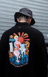 Remera oversize manga corta de algodón de color negro, con diseño holgado en pecho, hombros y mangas, y gran estampa colorida en la espalda.