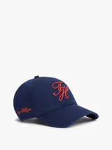 Gorra de béisbol azul marino con diseño de seis paneles y visera curva. Cuenta con bordado en color rojo en la parte frontal con las iniciales TH en fuente script y la firma de la marca en el lateral.