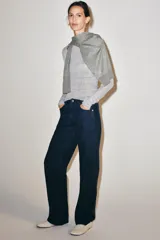 Jeans de tiro medio con diseño de perneras curvas y corte recto, confeccionados en denim con estampado paisley en tonos marrones y beige. Presentan diseño clásico de cinco bolsillos, trabillas para cinturón y cierre frontal con cremallera y botón metálico.