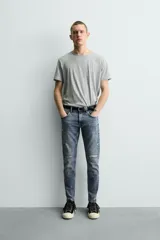 Jeans skinny fit de corte ajustado y tiro medio en color negro con efecto lavado y detalles desgastados. Confeccionados en tejido elástico con mezcla de algodón, presentan diseño clásico de cinco bolsillos y cierre frontal con cremallera y botón.