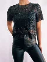 Remera negra de mangas cortas confeccionada en tejido de red con lentejuelas. Incluye top negro de breteles finos para usar debajo.