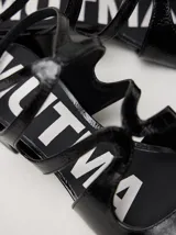 Sandalias de cuero con acabado charol color bordó, con punta cuadrada, tiras onduladas en el empeine y correa ajustable con hebilla en el tobillo. Cuentan con un taco bajo forrado.