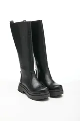 Bota de caña alta de ecocuero color negro, con cierre lateral y base con plataforma.