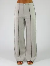 Pantalón marrón de lino de corte recto y holgado, con costuras decorativas claras a lo largo de las piernas.
