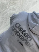 Canguro gris con capucha ajustable con cordones, bolsillo tipo canguro y logo estampado en el pecho.