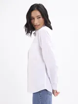 Camisa de corte clásico confeccionada en tela oxford color blanco, con cuello camisero, cierre frontal de botones, bolsillo aplicado en el pecho y puños abotonados.