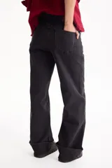 Jean wide leg negro con elastano, diseño de tiro alto y botamanga ancha con vuelta.