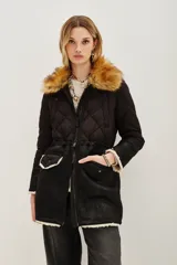 Campera negra de diseño híbrido con cuerpo acolchado en forma de rombos y mangas de textura lisa. Presenta un cuello de piel sintética desmontable en tono marrón y detalles de corderito en los puños y el ruedo. Incluye cierre frontal y cordones ajustables en la cintura.