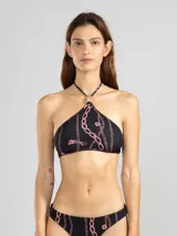 Top de bikini estilo halter color negro con estampado de cadenas y tigres en color rosado. Presenta un charm floral en el cuello. Ofrece protección UV50 y es resistente al cloro, protectores solares y aceites.