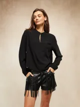 Blusa de manga larga color blanco, con cuello mao y pequeña abertura frontal con cierre de botón. Presenta un diseño de corte recto y tejido ligero.