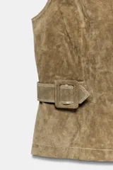 Chaleco de gamuza color marrón, con cuello alto, cierre frontal de cremallera y trabillas con hebilla a los lados de la cintura.