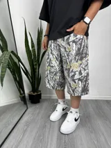 Bermuda de corte holgado con estampado de camuflaje de árboles en tonos blanco, gris y marrón.