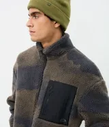 Campera de sherpa con estampa camuflada y cierre frontal, de manga larga, corte oversize, cuello alto y bolsillo negro contrastante en el pecho.