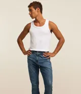 Pantalón de jean elastizado azul con lavado nevado, corte skinny y tiro medio.