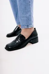 Mocasín de cuero con textura de reptil en color bordó, con punta cuadrada y taco bloque bajo de color negro.