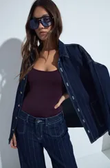 Body negro de escote cuadrado y silueta ajustada al cuerpo, sin mangas. Confeccionado en tejido de poliamida con elastano, de textura suave y elástica.