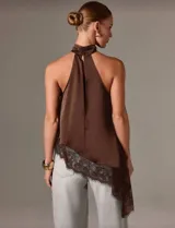Blusa sin mangas color marrón chocolate, con cuello halter asimétrico y detalle de encaje en el ruedo.