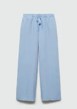 Pantalon wide leg de lino, color celeste, con cintura elástica y lazo de ajuste. Presenta costuras verticales frontales y bolsillos laterales.