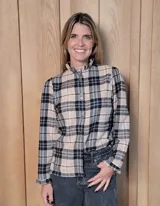 Camisa de manga larga con estampado de rayas verticales en tonos blanco y lila. Presenta cuello alto con volados, cierre frontal con doble botonadura y puños con volados.