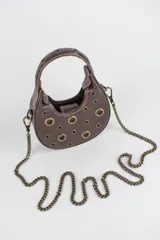 Cartera mini hobo estructurada de cuero negro, decorada con arandelas metálicas doradas en toda la superficie. Cuenta con asa corta de mano y correa de cadena metálica extraíble.