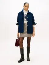 Mini falda de corte recto con estampado de cuadros en tonos beige y marrón. Presenta un diseño clásico con cierre frontal y estructura definida.