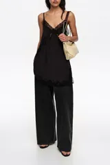 Pantalón de mezclilla negro de corte wide leg, con diseño holgado y tiro bajo.