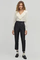 Pantalón sastrero negro de tiro alto con silueta tipo carrot. Tiene cintura ceñida con pliegues en el frente, bolsillos laterales y un bolsillo de ojal en la parte trasera. Confeccionado con taffeta.