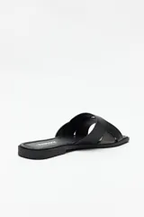 Sandalias bajas plateadas con tiras anchas cruzadas en el empeine y suela plana color marrón.