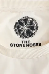Remera de punto suave de algodón, color beige, con hombros ligeramente caídos y cuello redondo ribeteado acanalado. Cuenta con estampa frontal de la banda The Stone Roses con ilustración de un limón y texto.