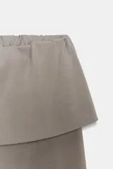 Pantalón de algodón compacto color beige, de tiro alto con cintura elástica y detalle de fajín y cordones.