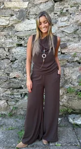 Pantalón de corte oxford y pierna ancha, color chocolate, con pretina frontal lisa, elástico en la parte posterior y bolsillos laterales.
