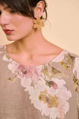 Aros de metal en forma de flor texturizada con centro de cuentas.