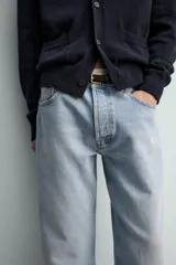 Pantalón de jean color celeste con efecto lavado, de corte recto y tiro medio, con diseño de cinco bolsillos y cierre frontal con botones.