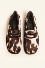 Mocasin de cuero con pelo estampado animal print tipo vaca, con punta cuadrada y suela plana de goma.