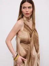 Vestido midi sin mangas, con estampado efecto mármol en tonos marrones y beige, cuello halter y detalle de choker incorporado.