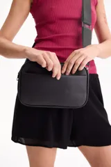 Bandolera Aurea de poliuretano símil cuero color negro, con diseño rectangular y bolsillo frontal externo. Cuenta con cierre superior y correa ajustable.