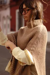 Poncho tejido de lana con cuello alto y diseño de calce relajado, ideal para capas de abrigo.