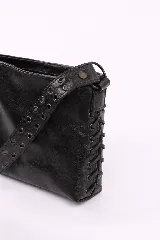 Bandolera de cuero negro con diseño rectangular, caracterizada por una correa ancha decorada con múltiples ojales metálicos y detalles de costuras laterales entrelazadas.