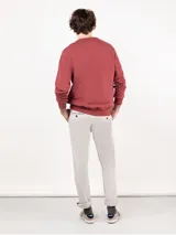 Sudadera de felpa color ladrillo, con cuello redondo, manga larga y logo estampado en el pecho.