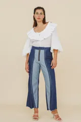 Jean de corte recto confeccionado en denim de algodón, con diseño bicolor que combina paneles en azul oscuro y azul claro. Presenta cierre frontal con cremallera y diseño de costuras verticales marcadas.