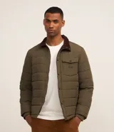 Campera puffer verde militar acolchada de manga larga, con cierre frontal de cremallera y botones a presión. Cuenta con cuello camisero de corduroy marrón oscuro, un bolsillo en el pecho con solapa y botones, y bolsillos laterales.