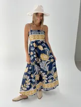 Vestido largo de algodón italiano con estampado floral en tonos azul, amarillo y blanco. Tiene escote cuadrado, corte imperio y elástico en la espalda.