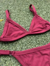 Conjunto de bikini bordó con corpiño triangular fijo y bombacha colaless regulable. Incluye abertura para agregar tazas soft.