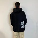 Canguro negro oversize con capucha y bolsillo tipo canguro. Presenta una estampa pequeña con la frase "feel the vibes" en el pecho y un logo en la parte inferior.