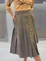 Falda midi de lana estampada a mano con engomado brillante tono sobre tono y tablas irregulares hechas a mano. Tiene bolsillos laterales.