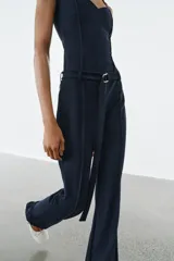 Top de escote en pico con tirantes finos ajustables. Presenta un diseño entallado con costuras verticales decorativas en el frente y bajo recto.